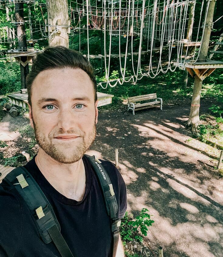 Man on a ropes course with ropes in the background