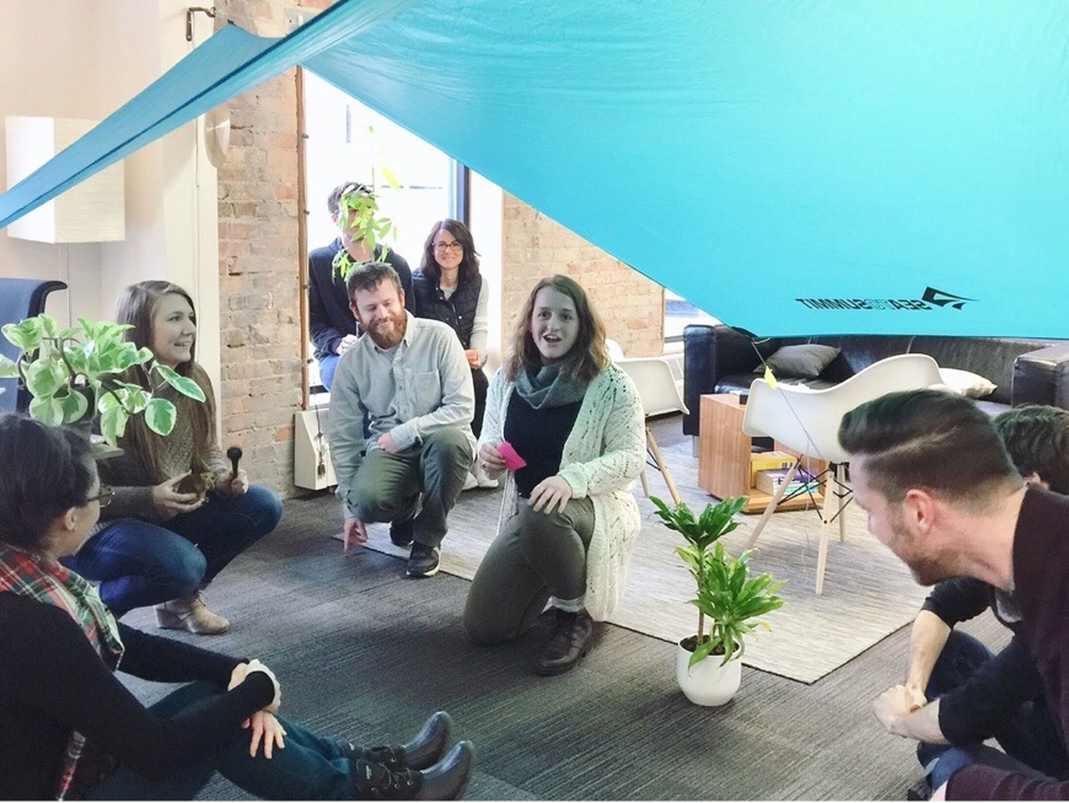 Picture of the Mighty team huddled under a tent pitched in the office